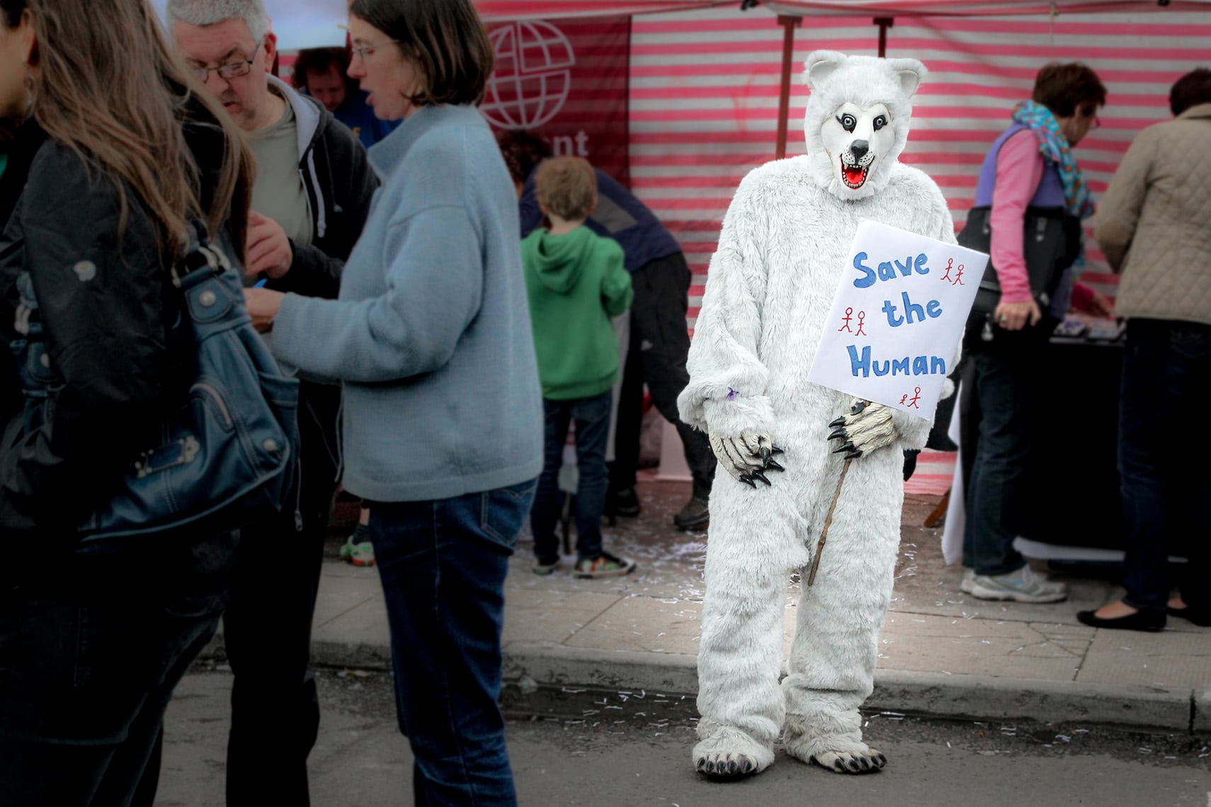 Polar bear with a sign that reads "Save the Human" to highlight Climate Change